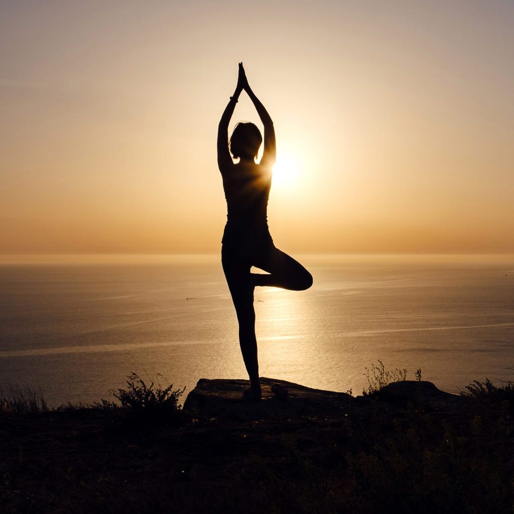 A Woman Do a Yoga Posture On The Mountain At Sunset